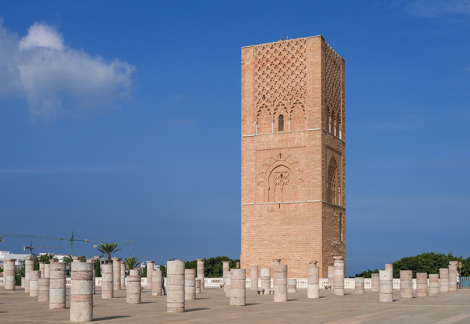 The Hassan Tower's unfinished sandstone minaret rising above rows of ancient stone columns under a clear blue sky in Rabat, Morocco