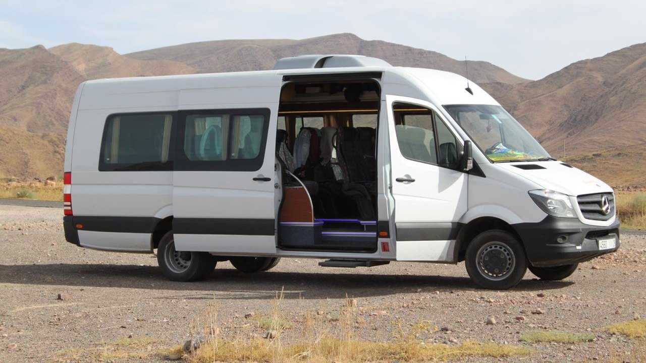 White Mercedes Sprinter passenger minibus in the Moroccan desert